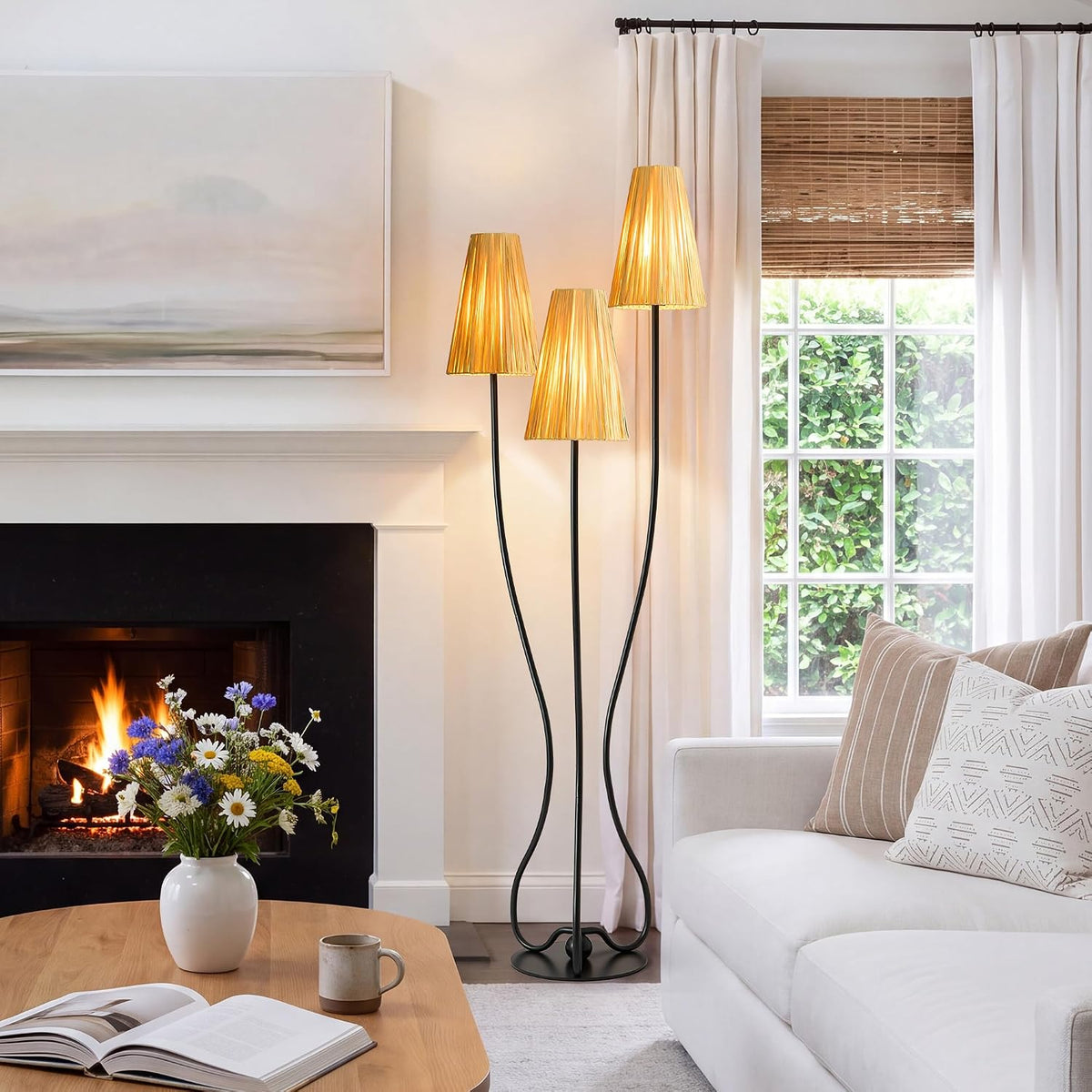 Glowing raffia floor lamp beside a sofa, window and wooden coffee table